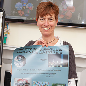 Smiling woman with short red hair holding a poster