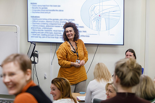 smiling woman in classroom at the northern college of acupuncture