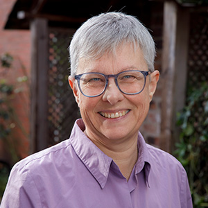 smiling woman with glasses and short grey hair