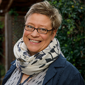 smiling woman in glasses with short blonde hair