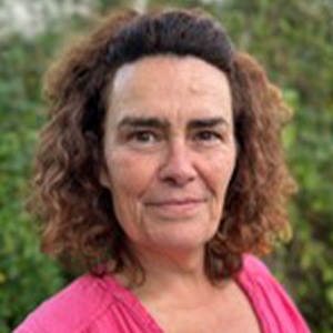 smiling woman with dark hair in pink shirt